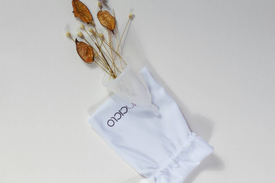 Soft linen reusable eye mask resting on natural wooden surface with dried lavender
